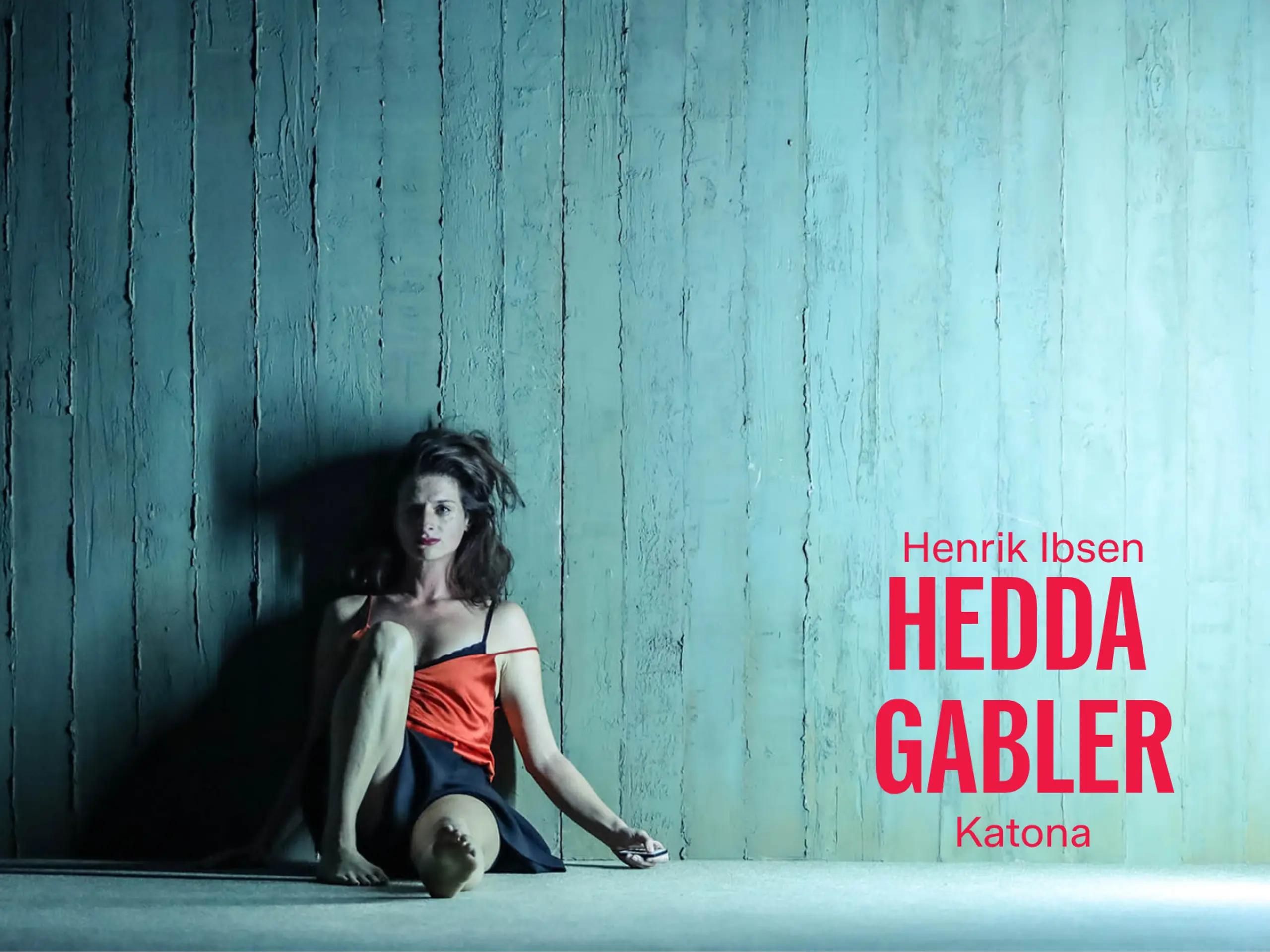 Kvinne sitter inntil en vegg. Hun ser sliten ut. Med tekst Henrik Ibsen Hedda Gabler Katona