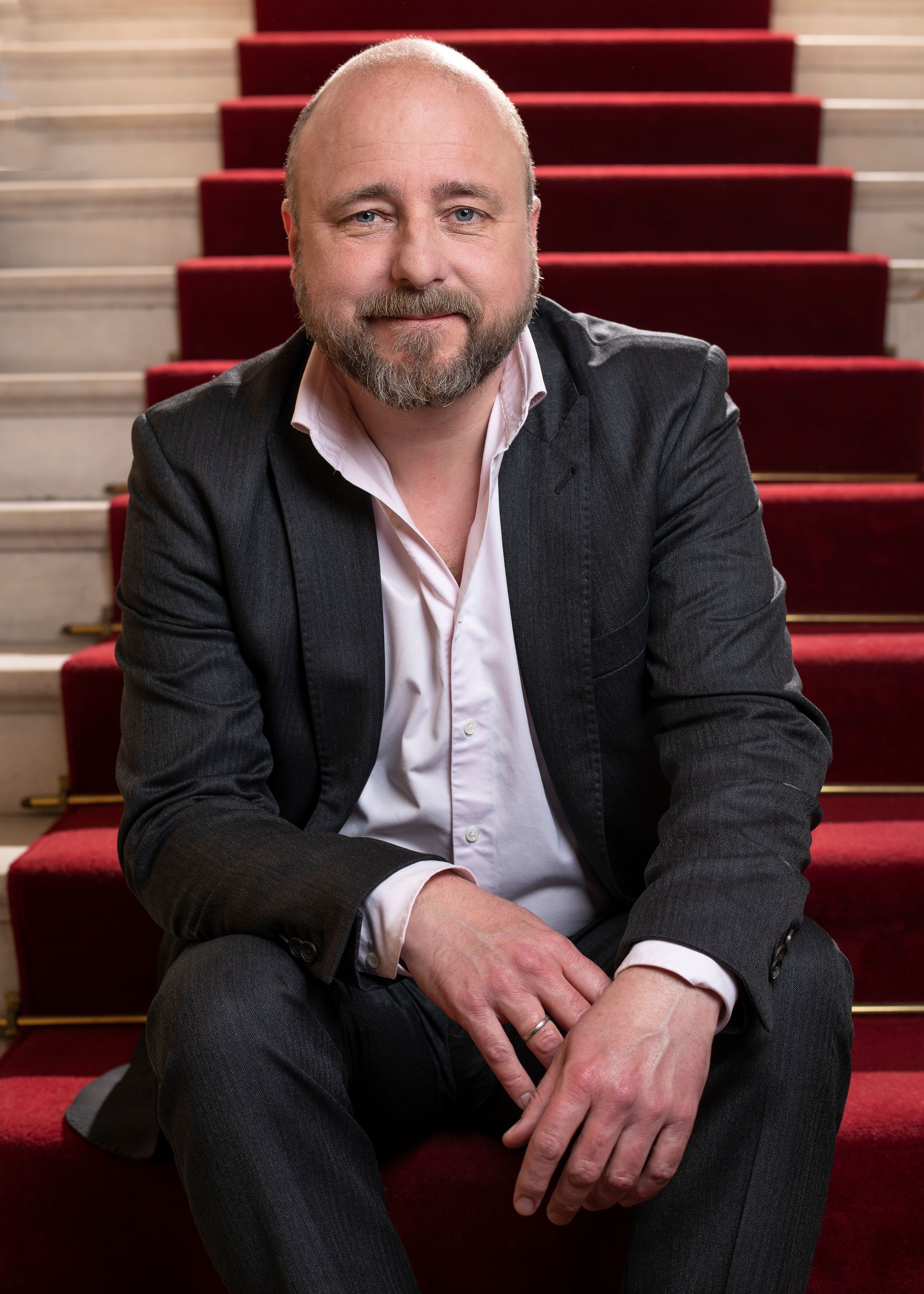 Portrett av teatersjef Kristian Seltun som sitter i trapp