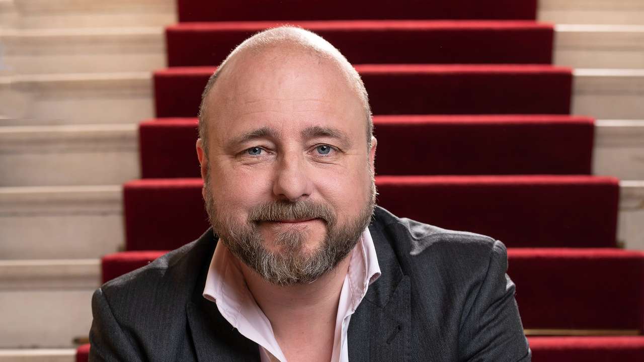 Portrett av teatersjef Kristian Seltun som sitter i trapp