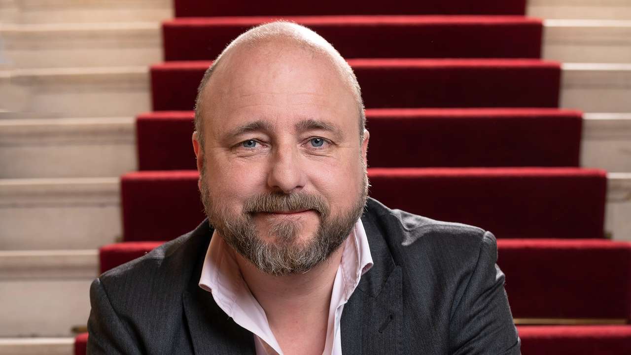 Portrett av teatersjef Kristian Seltun som sitter i trapp