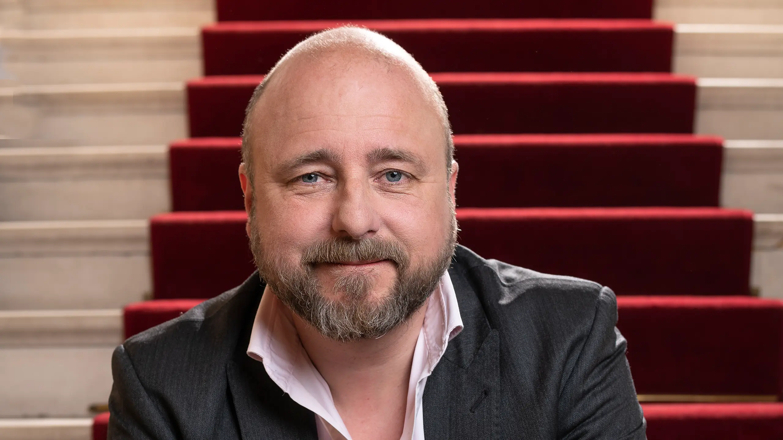 Portrett av teatersjef Kristian Seltun som sitter i trapp