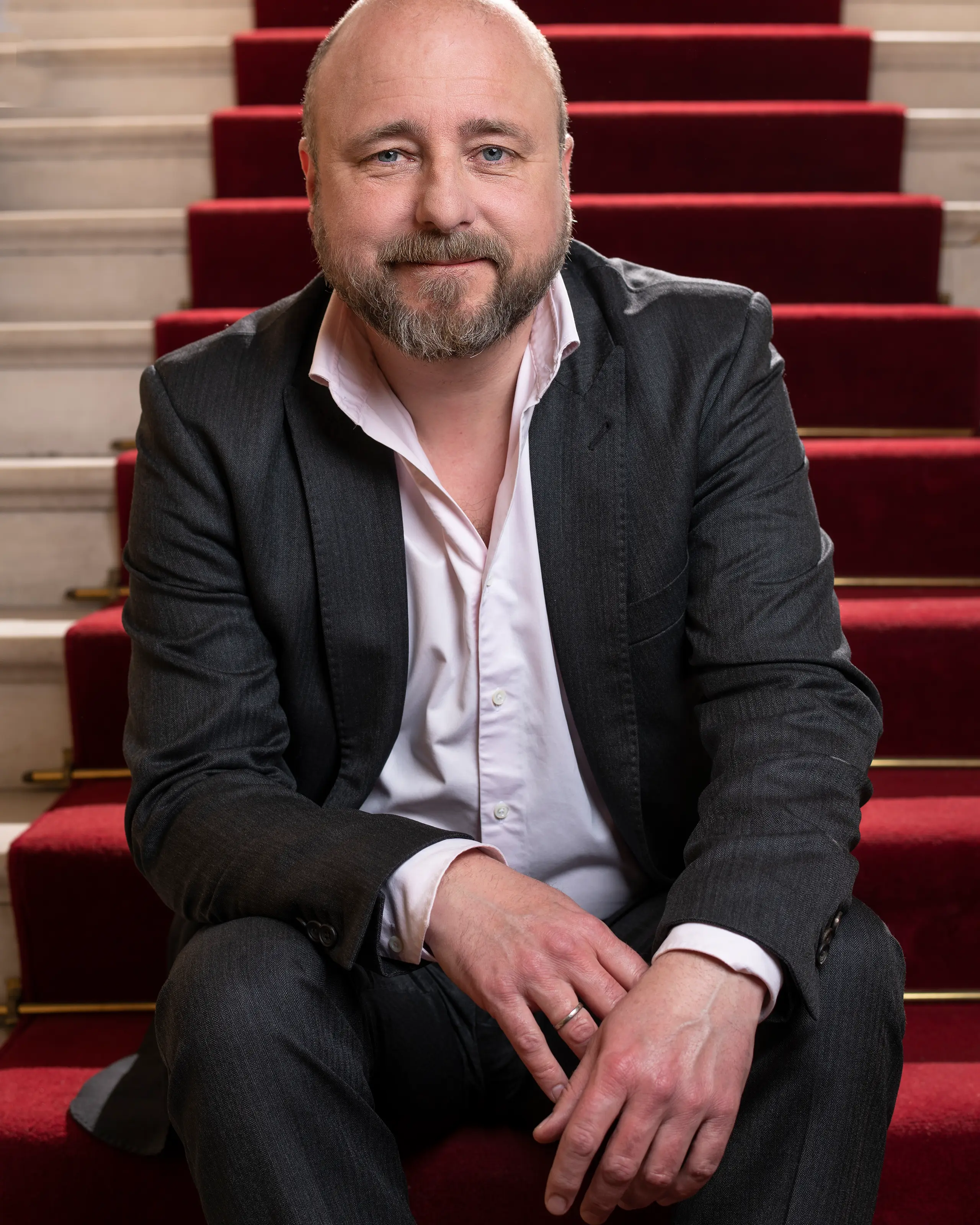 Portrett av teatersjef Kristian Seltun som sitter i trapp