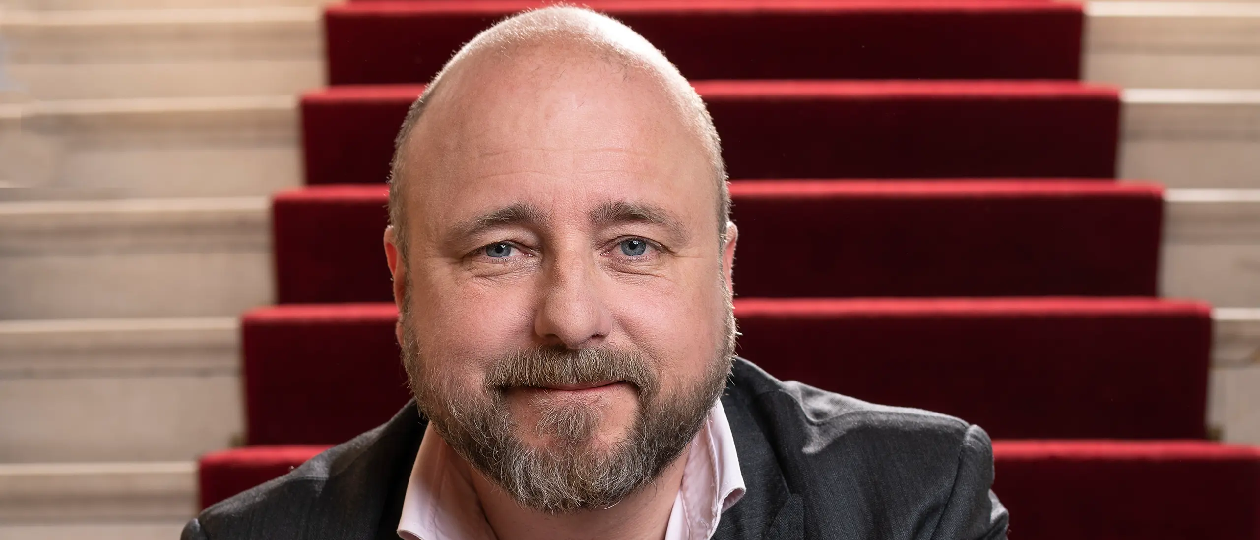 Portrett av teatersjef Kristian Seltun som sitter i trapp