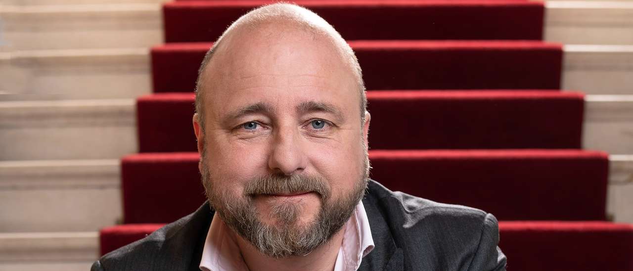 Portrett av teatersjef Kristian Seltun som sitter i trapp