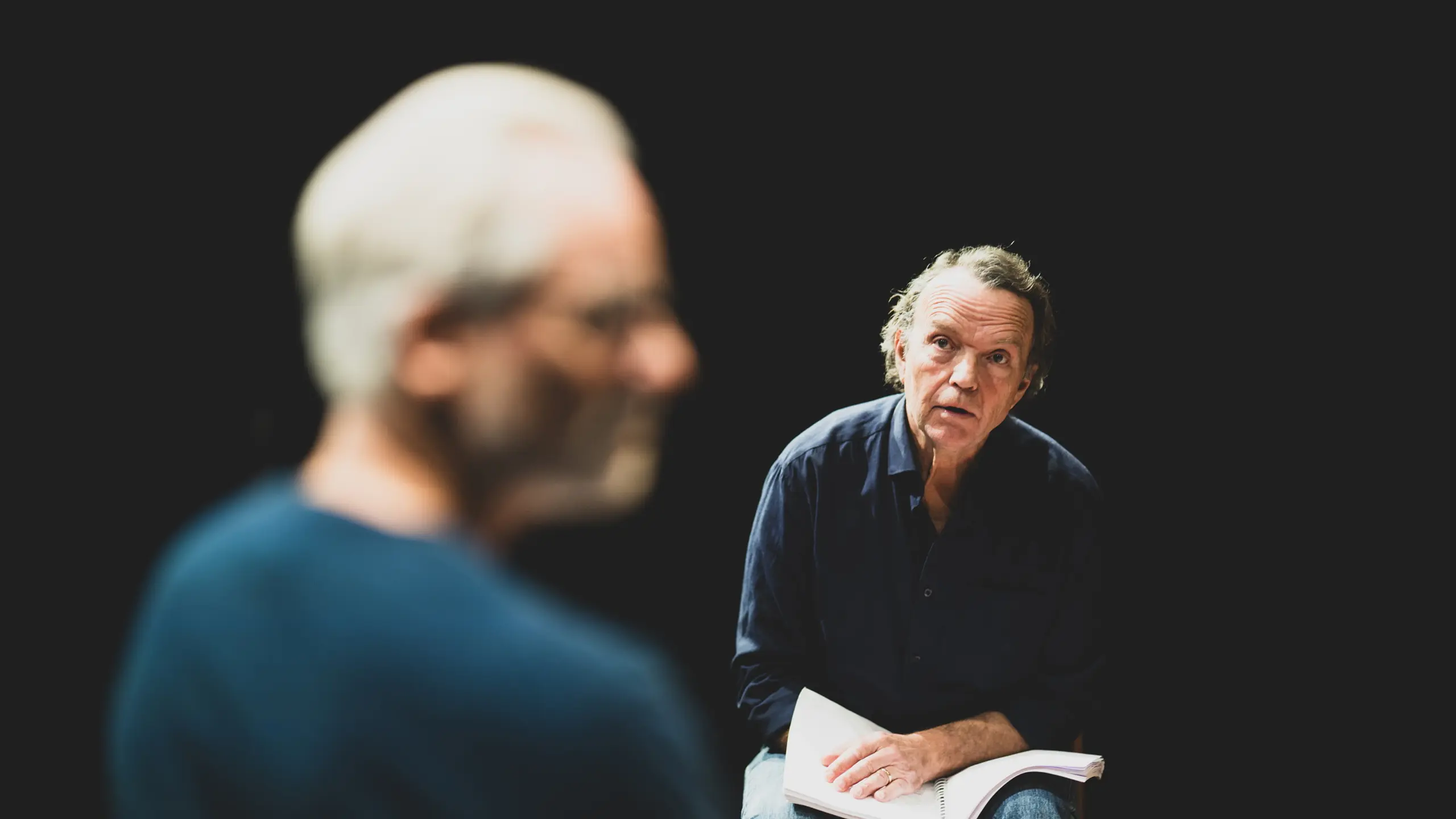 Mann ser på en annen mann mens han holder et manus