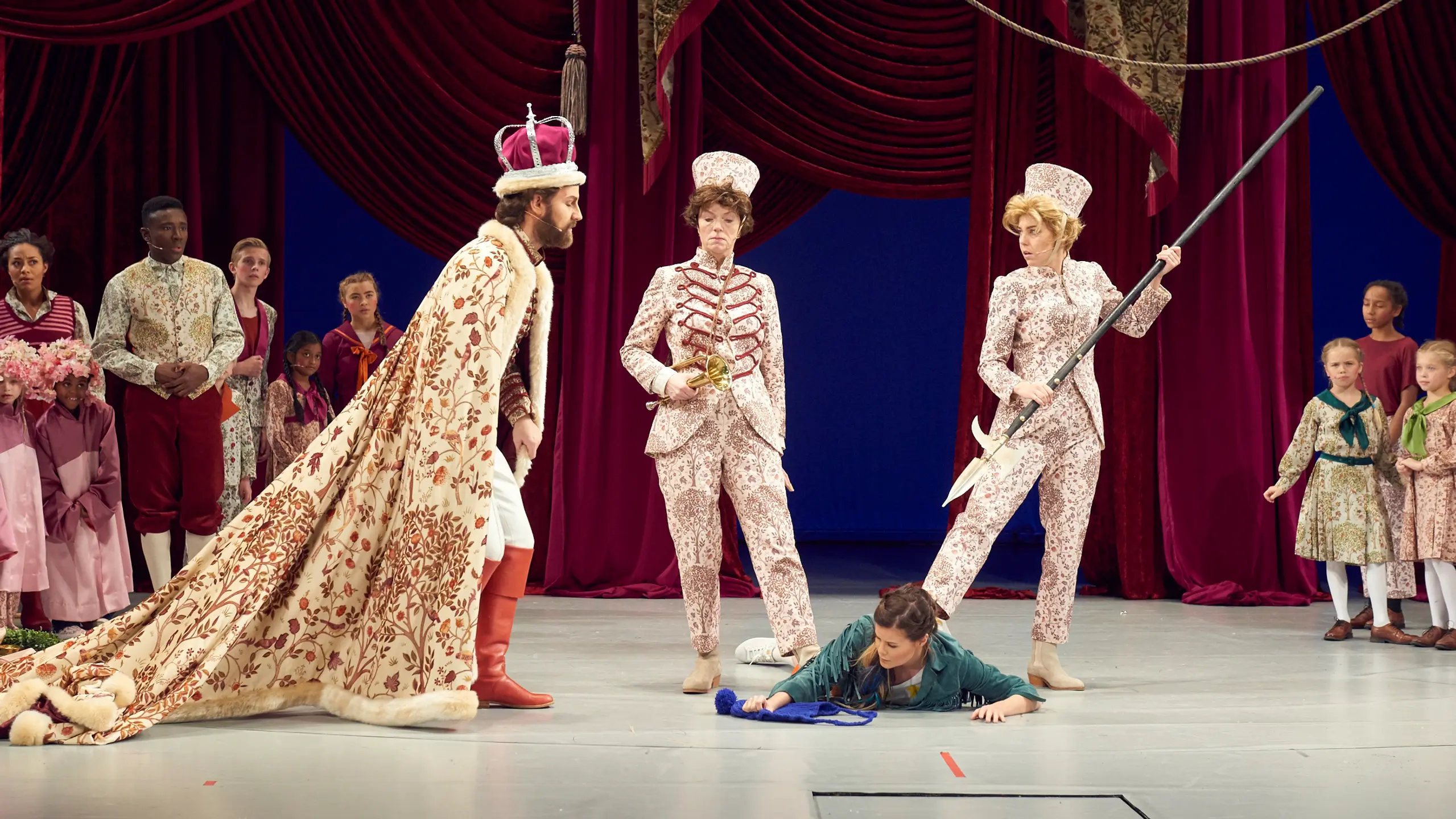 Soldater holder en jente nede, mens en konge ser på henne.