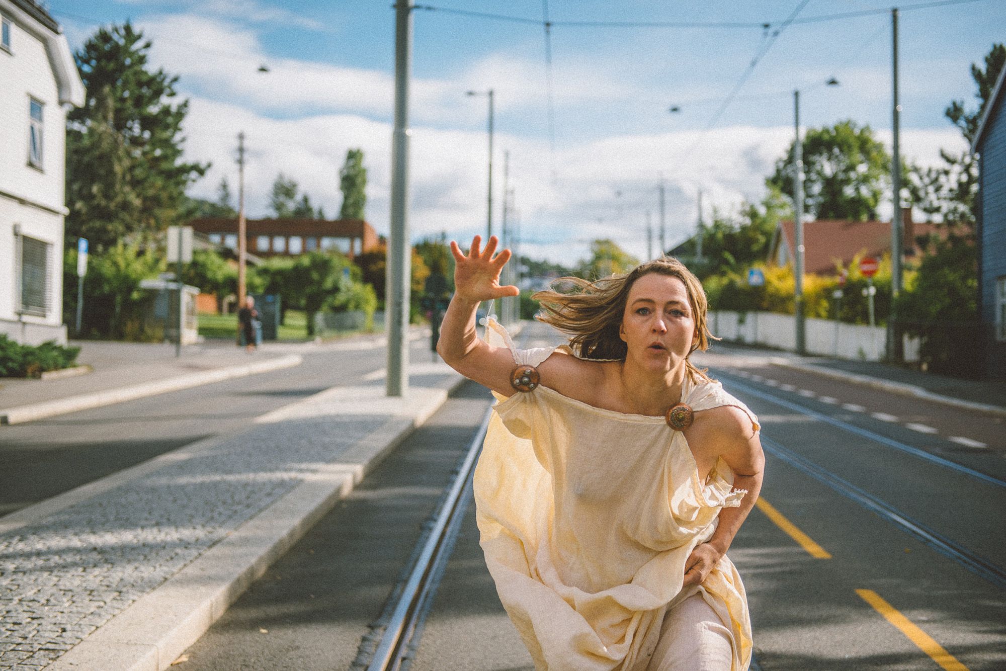 Kvinne i toga løper nedover gata