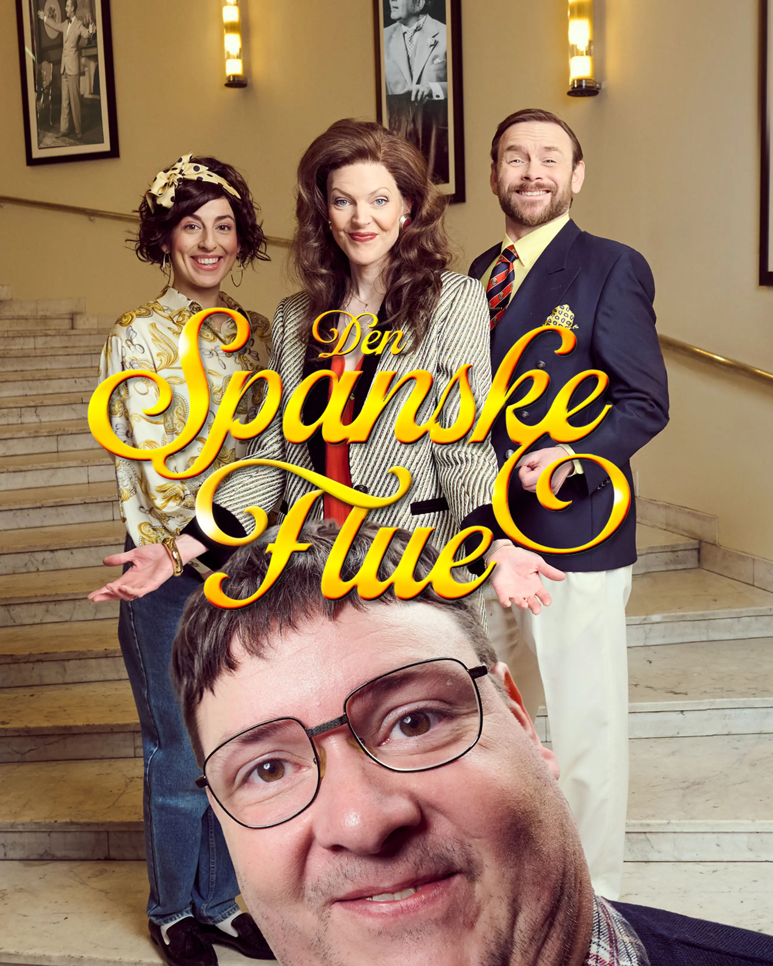 tre personer i fargerike kostymer poserer smilende i en trapp med marmor og palmer, mens én mann står tett foran kamera med briller og rød sløyfe.