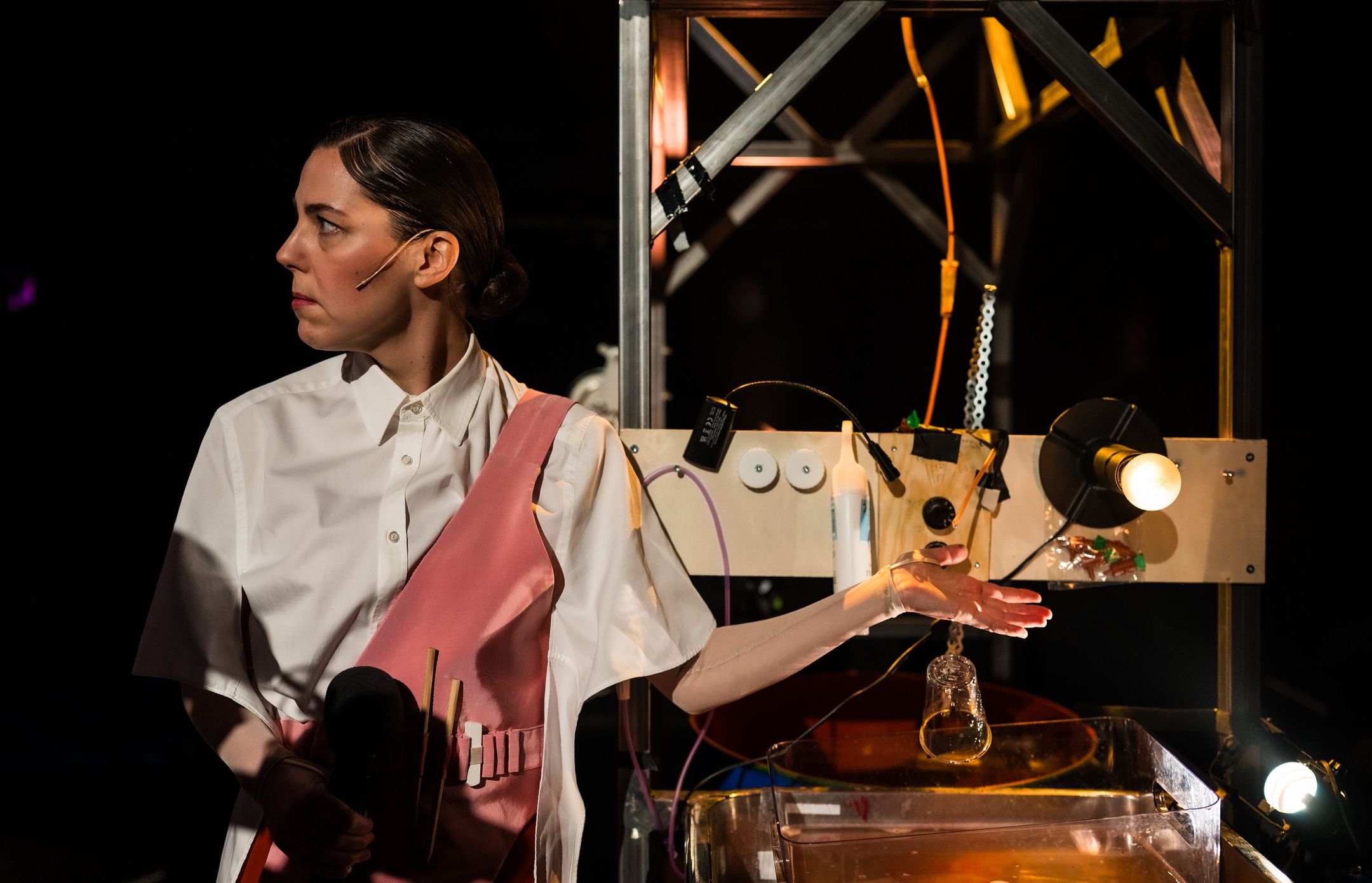 Kvinne ser til siden, mens hun holder hånda under dryppende vann over en vask med vann og lys