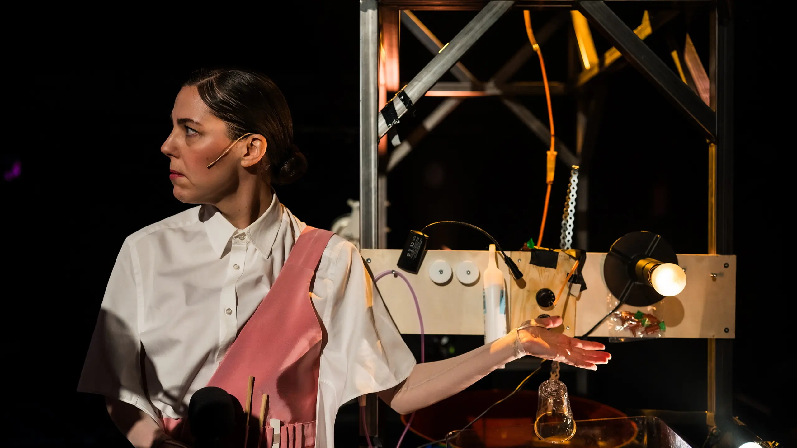 Kvinne ser til siden, mens hun holder hånda under dryppende vann over en vask med vann og lys