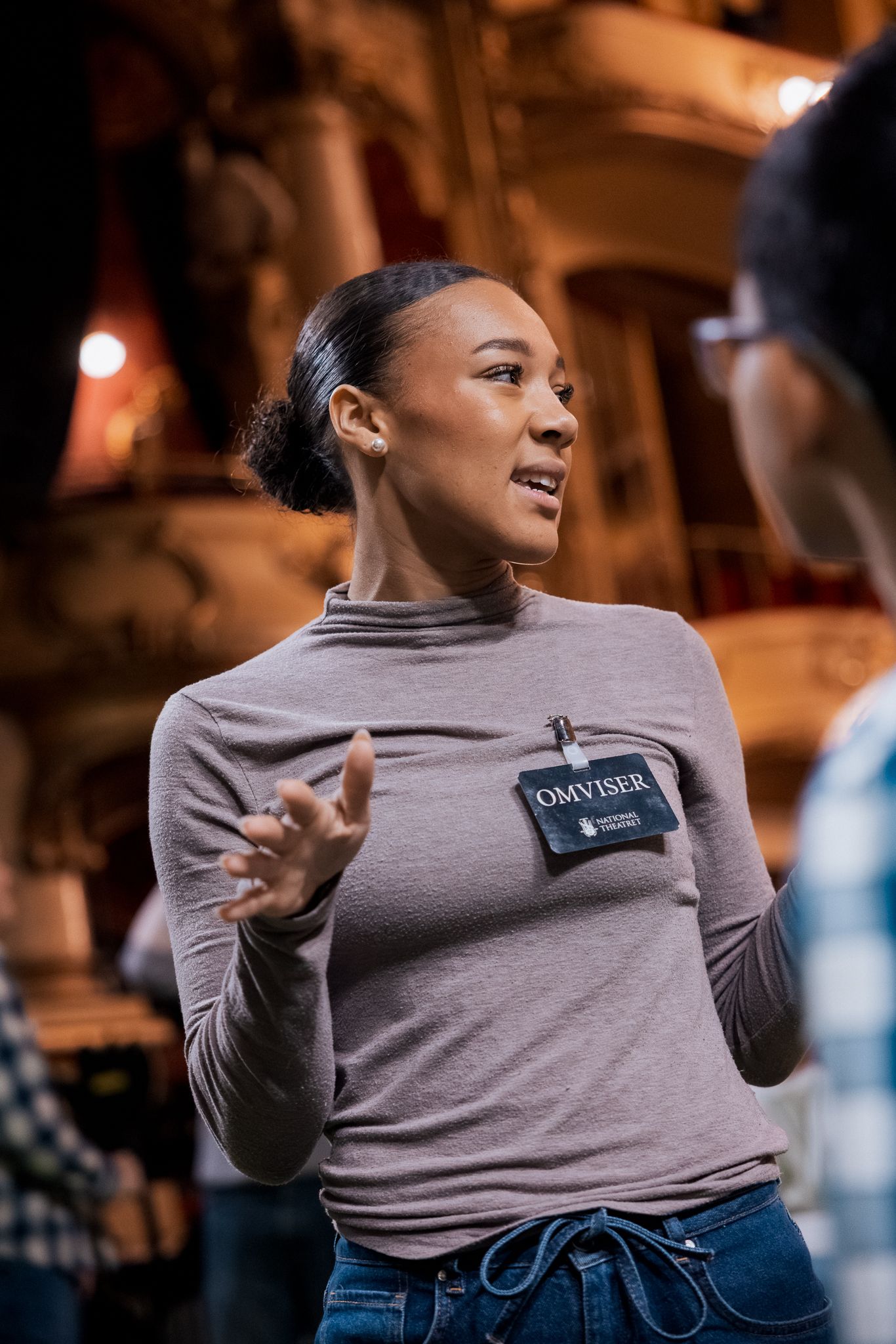 Kvinne på Hovedscenen med "omviser"-skilt på genseren