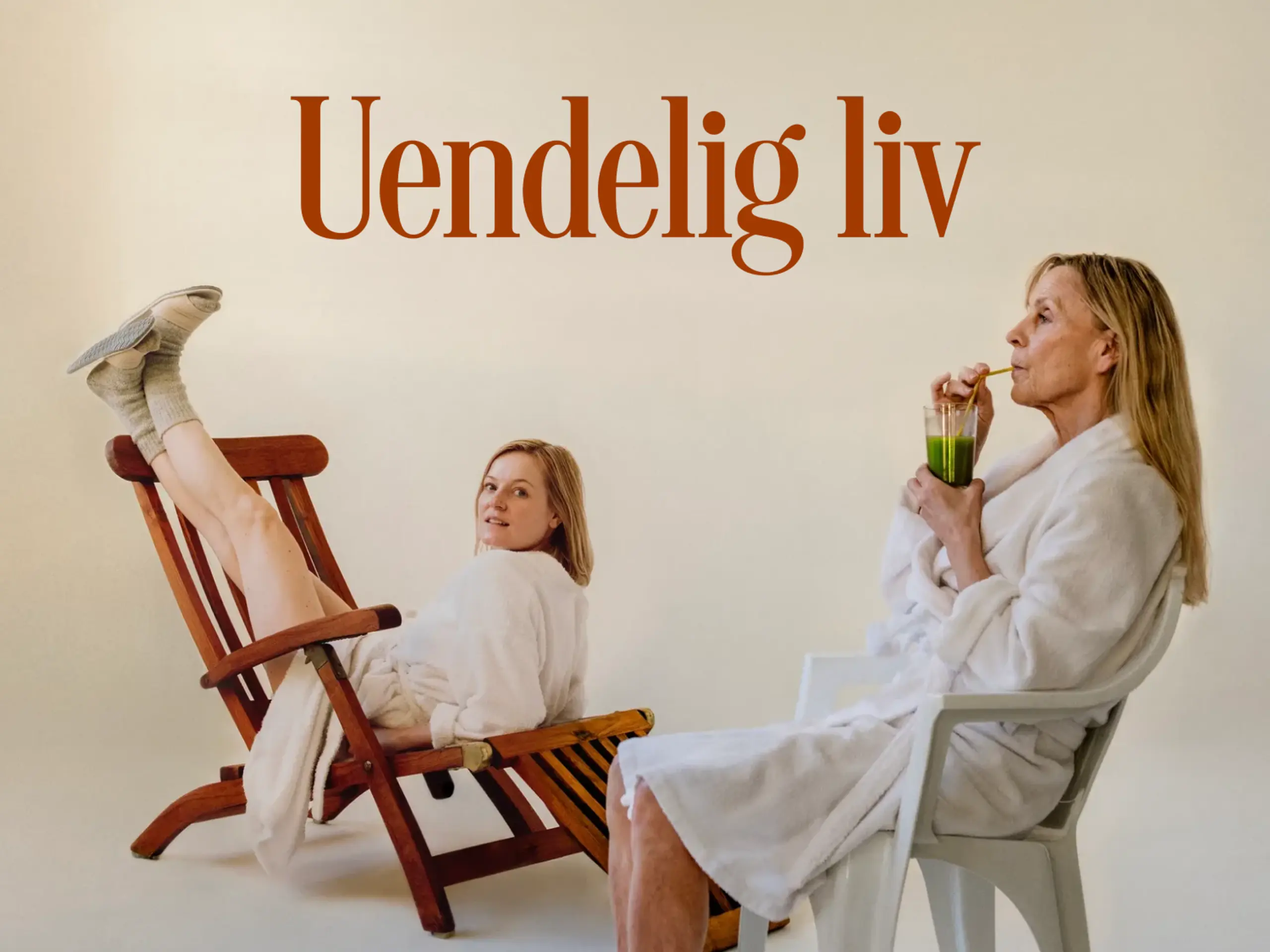 To kvinner i hvite morgenkåper. Den ene drikker en grønn jus mens hun sitter i en hvit plaststol. Den andre sitter feil vei med beina opp på en brun solseng mens hun ser mot kamera. Med tekst "Uendelig liv".