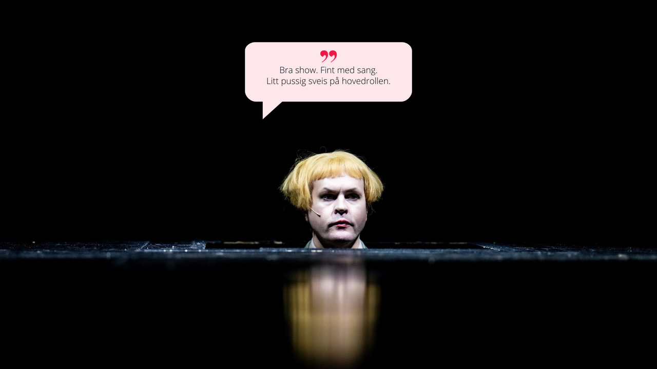 Et nærbilde av hovedpersonen med karakteristisk blond soppklipp, som ser alvorlig og oppmerksom ut. Mørk bakgrunn gir fokus på ansiktet. Sitat i snakkeboble: "Bra show. Fint med sang. Litt pussig sveis på hovedrollen."