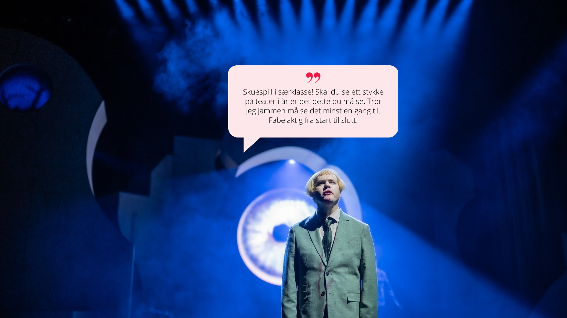 En skuespiller i lysegrønn dress står under et blått scenelys med en enorm, lysende projeksjon av et øye i bakgrunnen. Det skapes en dramatisk og intens stemning. Sitat i snakkeboble: "Skuespill i særklasse! [...] Fabelaktig fra start til slutt!"
