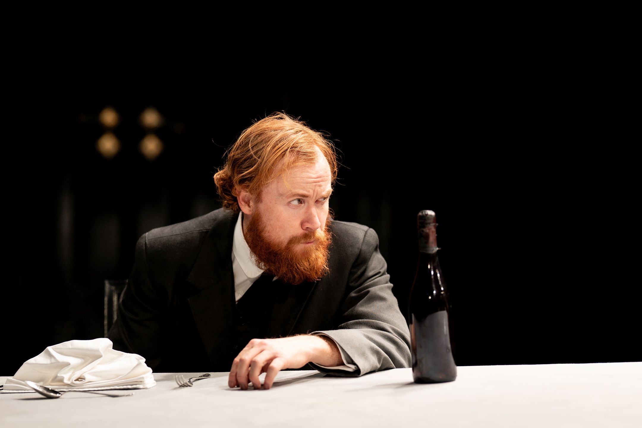 Morsk mann sitter ved et bord med en flaske foran seg