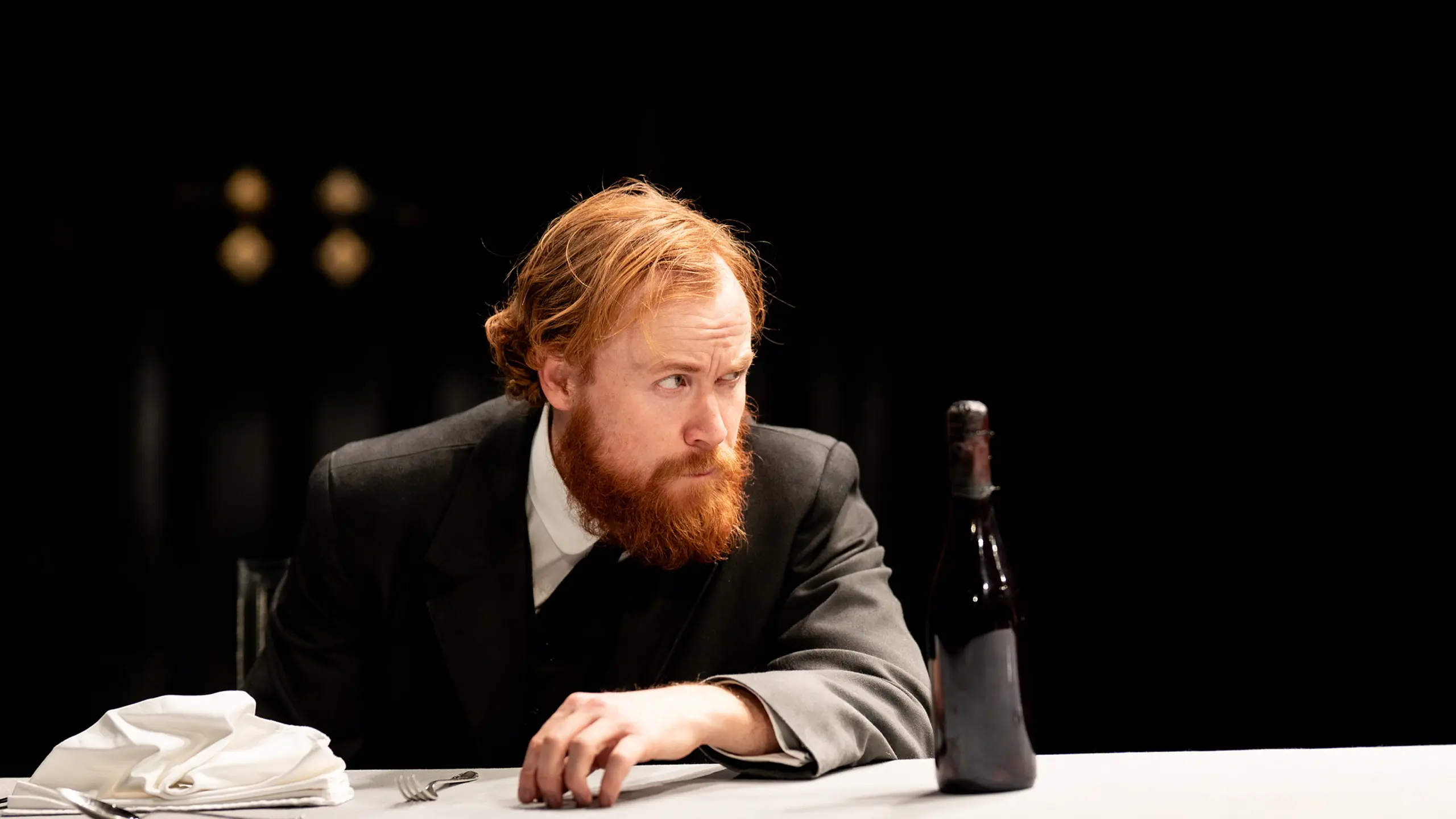 Morsk mann sitter ved et bord med en flaske foran seg