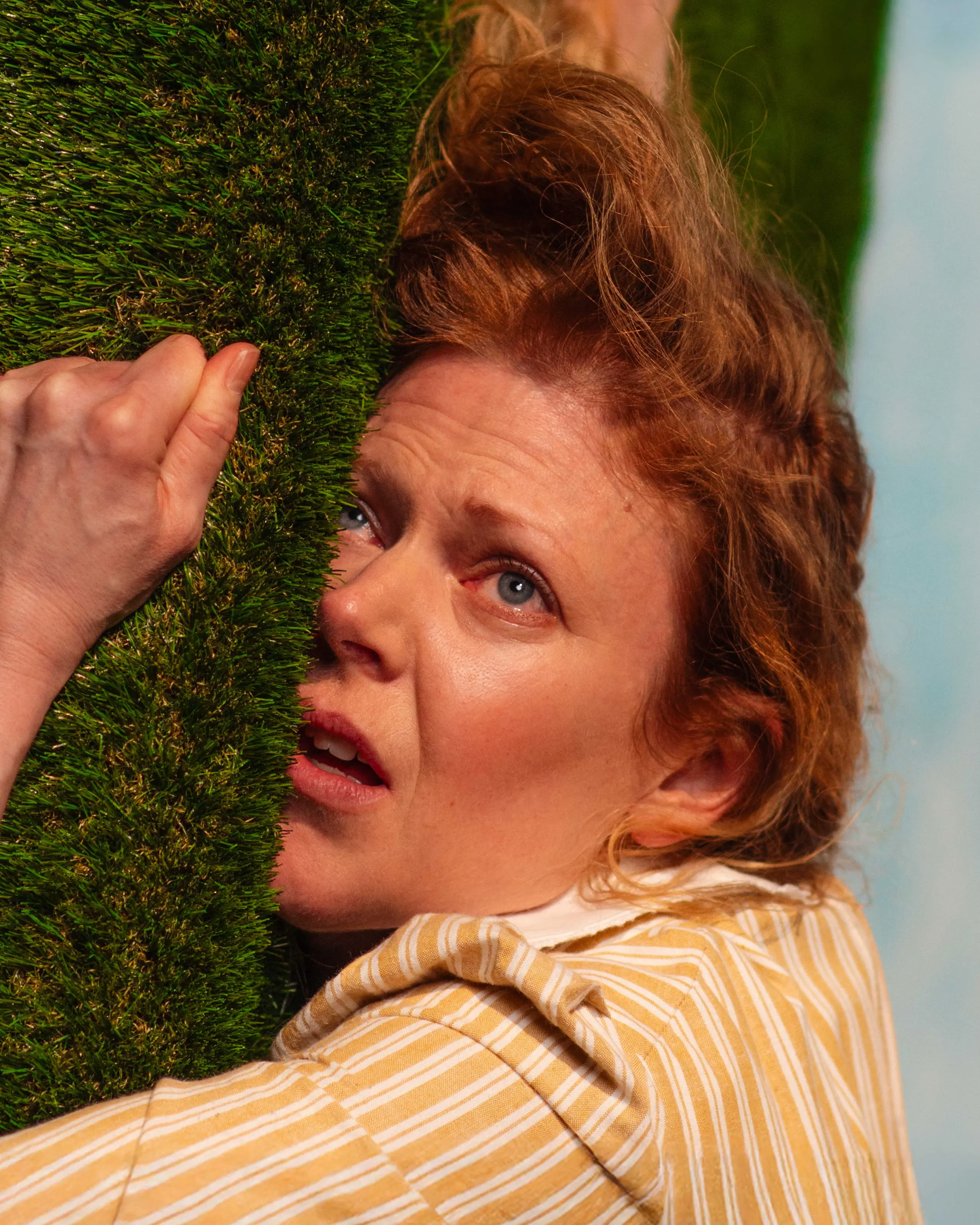 Kvinne som klamrer seg til kunstgress i tiltet bilde