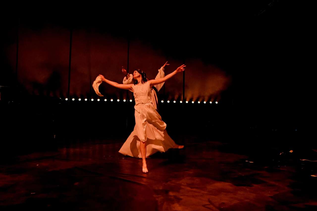 Kvinne i hvite klær danser på scenen