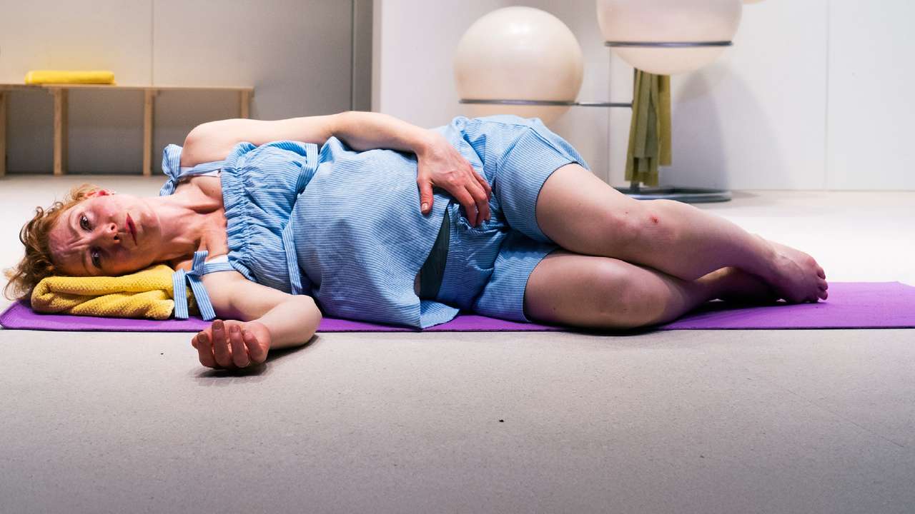 Fødende kvinne som ligger på siden i et yogastudio