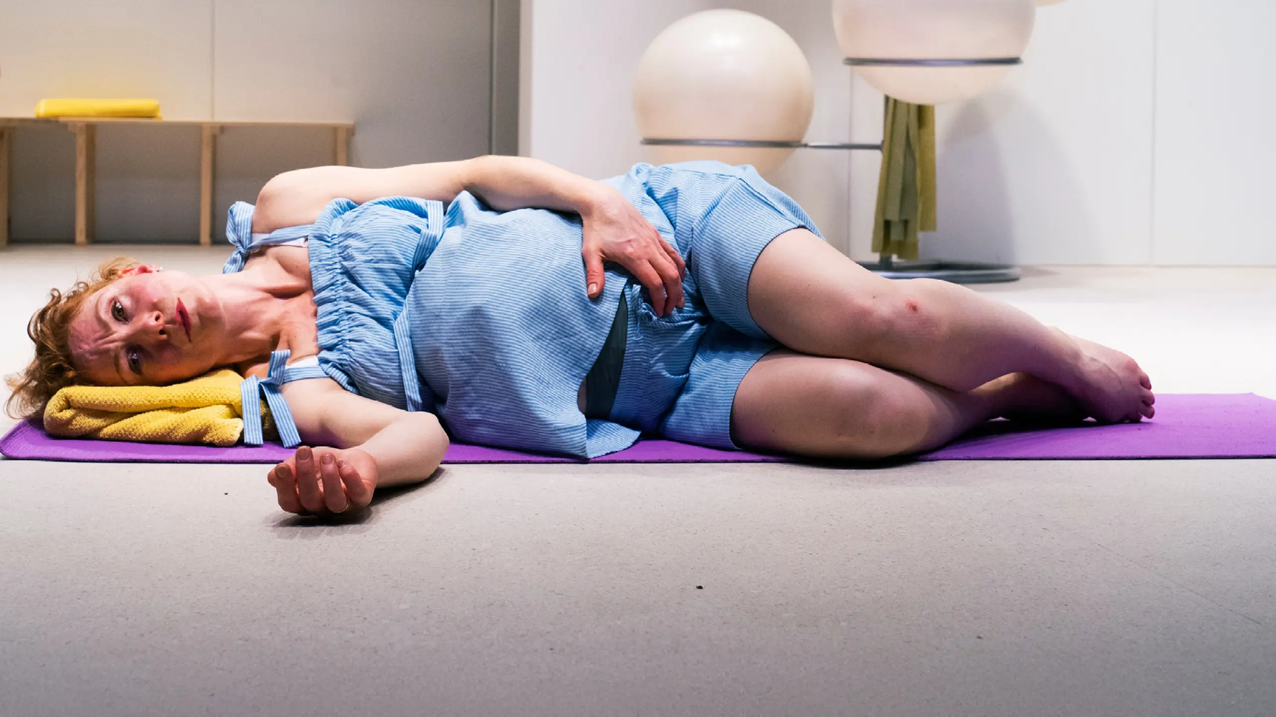 Fødende kvinne som ligger på siden i et yogastudio