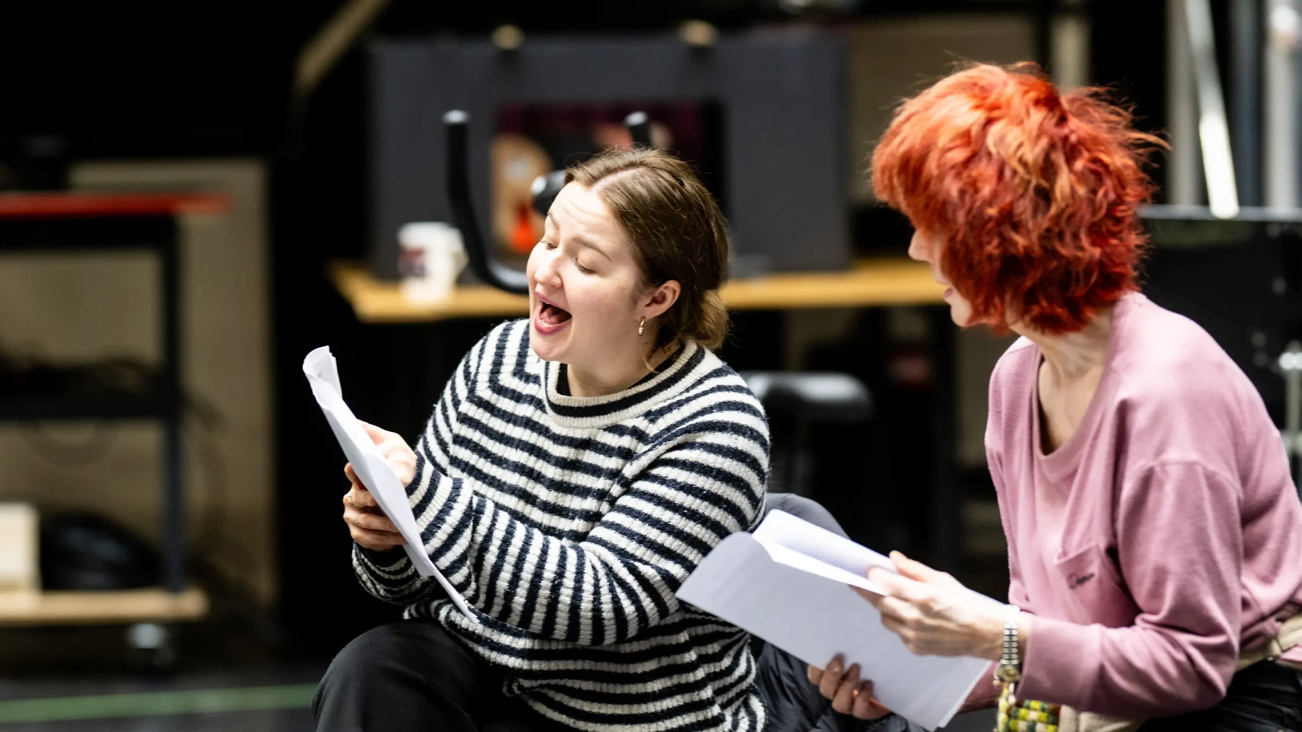 To kvinner sitter og leser manus.