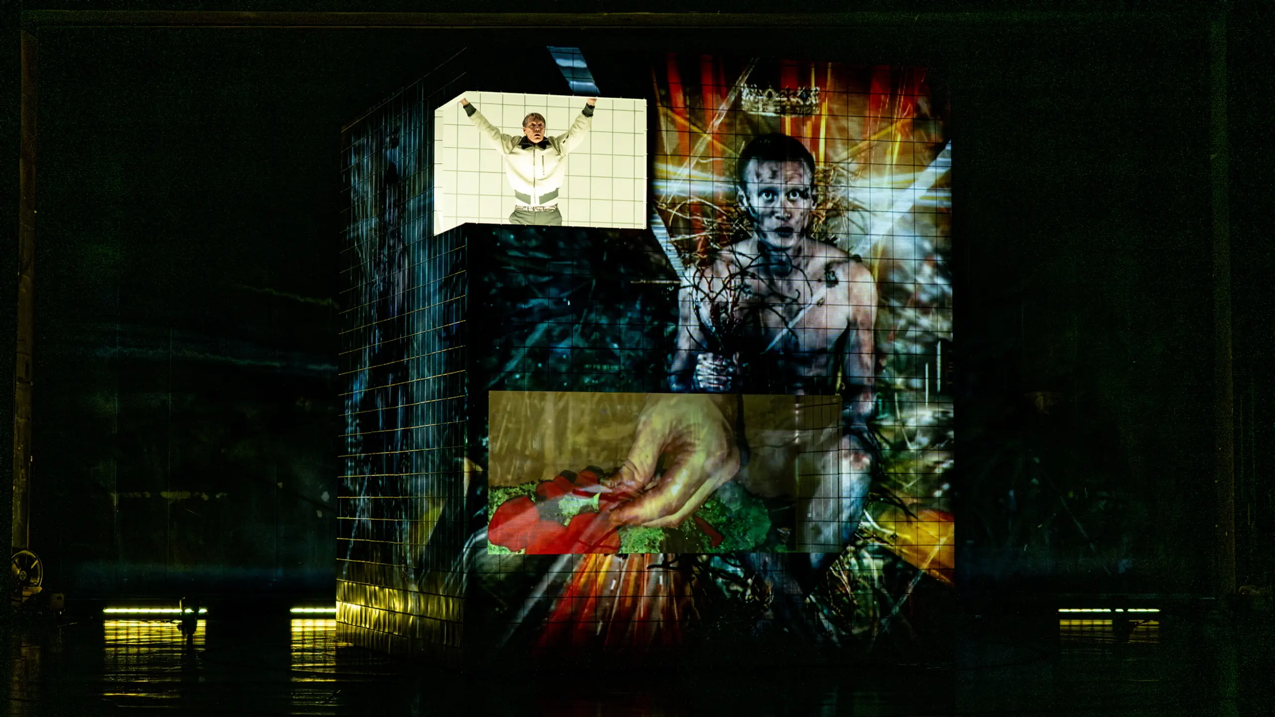 Person strekker armene ut øverst på en projisert kube med surrealistisk bilde av mann med krone og tornekrans.