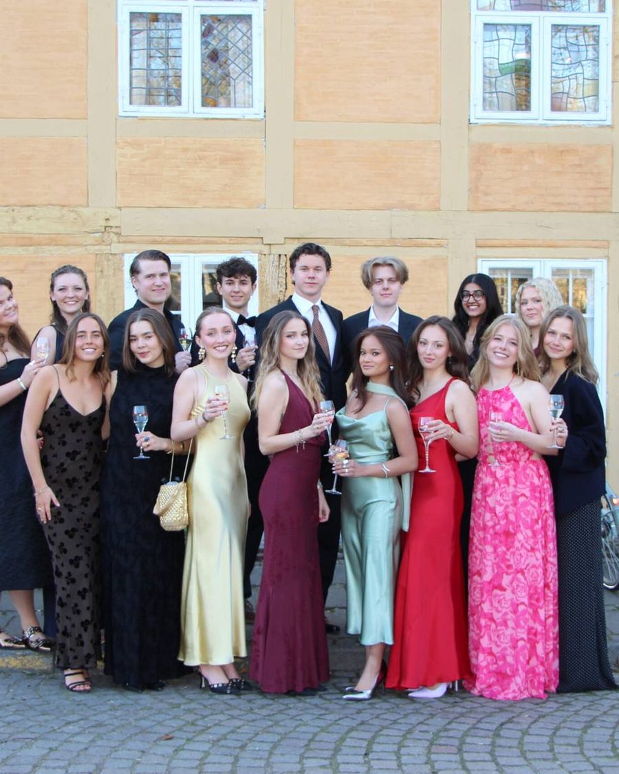 DM students in gala dress posing together outside