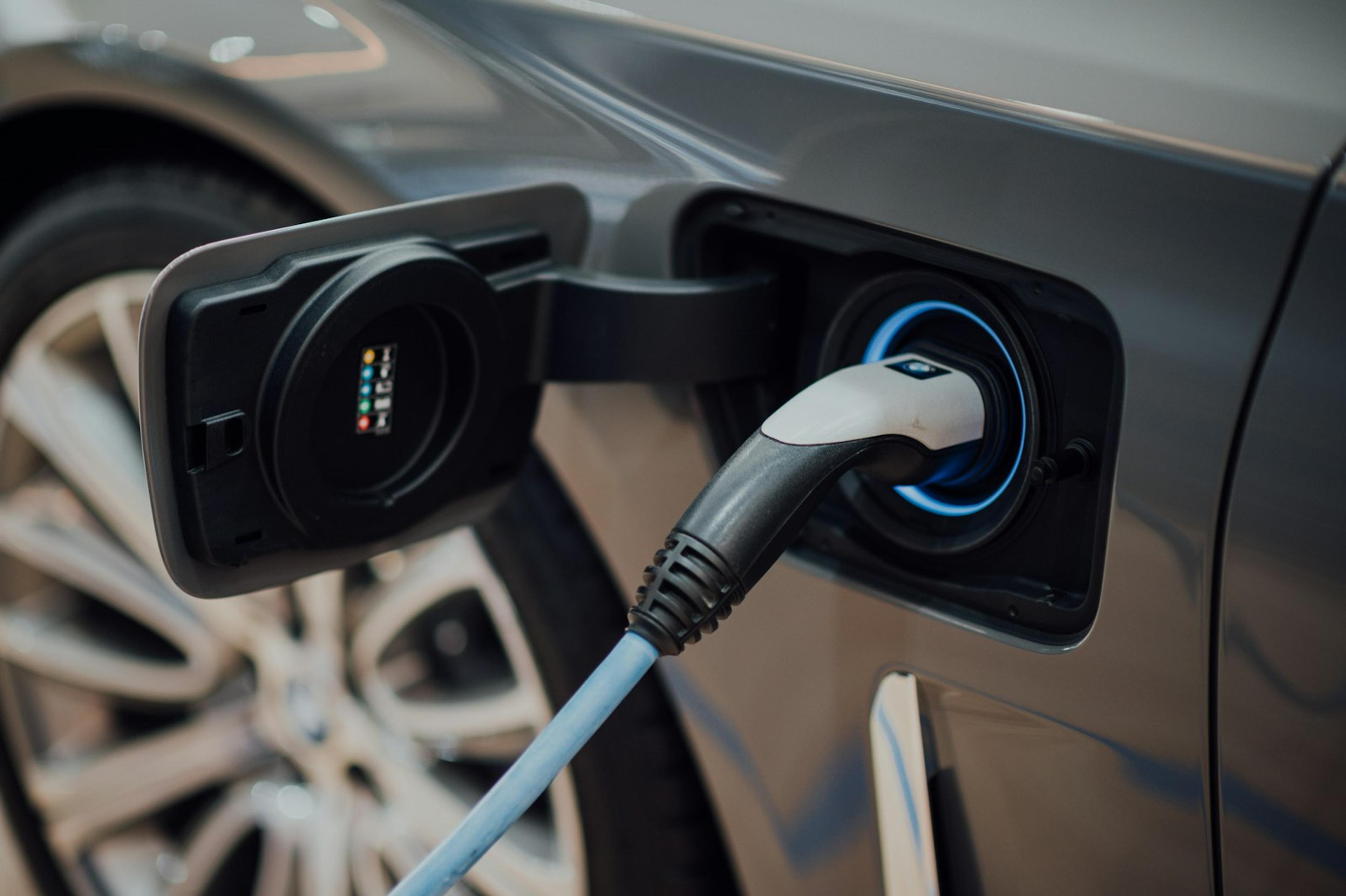 Electric vehicle charging cable plugged into a car at a charging station