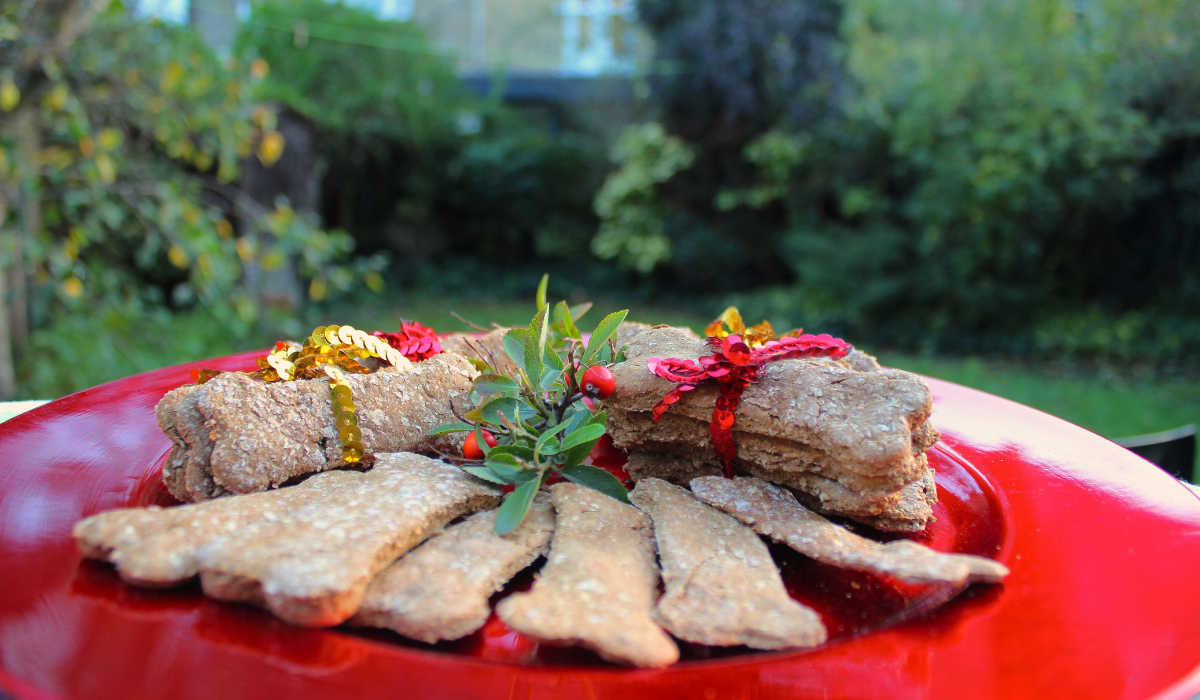 A plate of Gingerbread Bones with decorative holly and bows.