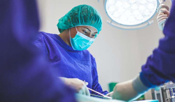 Veterinary nurse in surgery wearing scrubs and a mask