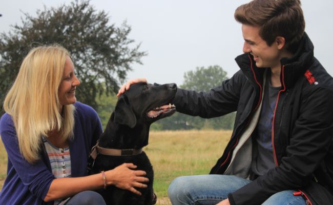 Doggy member Oso with owner Anna and borrower Michael enjoying pets