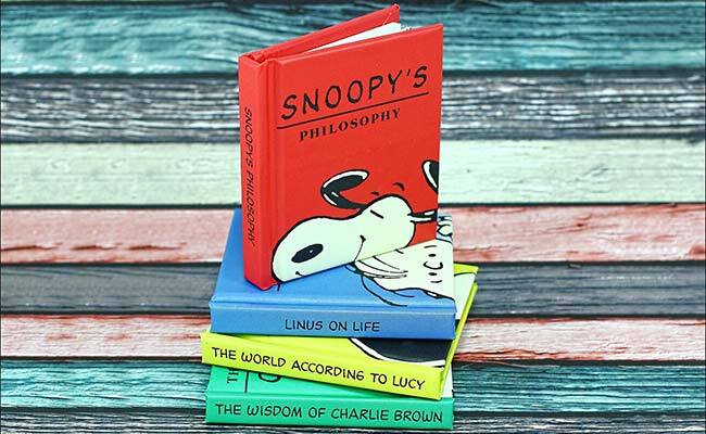 Stack of Snoopy books, first book, stood upright is titled 'Snoopy's Philosophy'