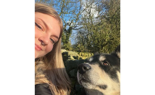 Student Grace with her borrowed dog, Blackie the Husky pausing on a walk for a selfie together