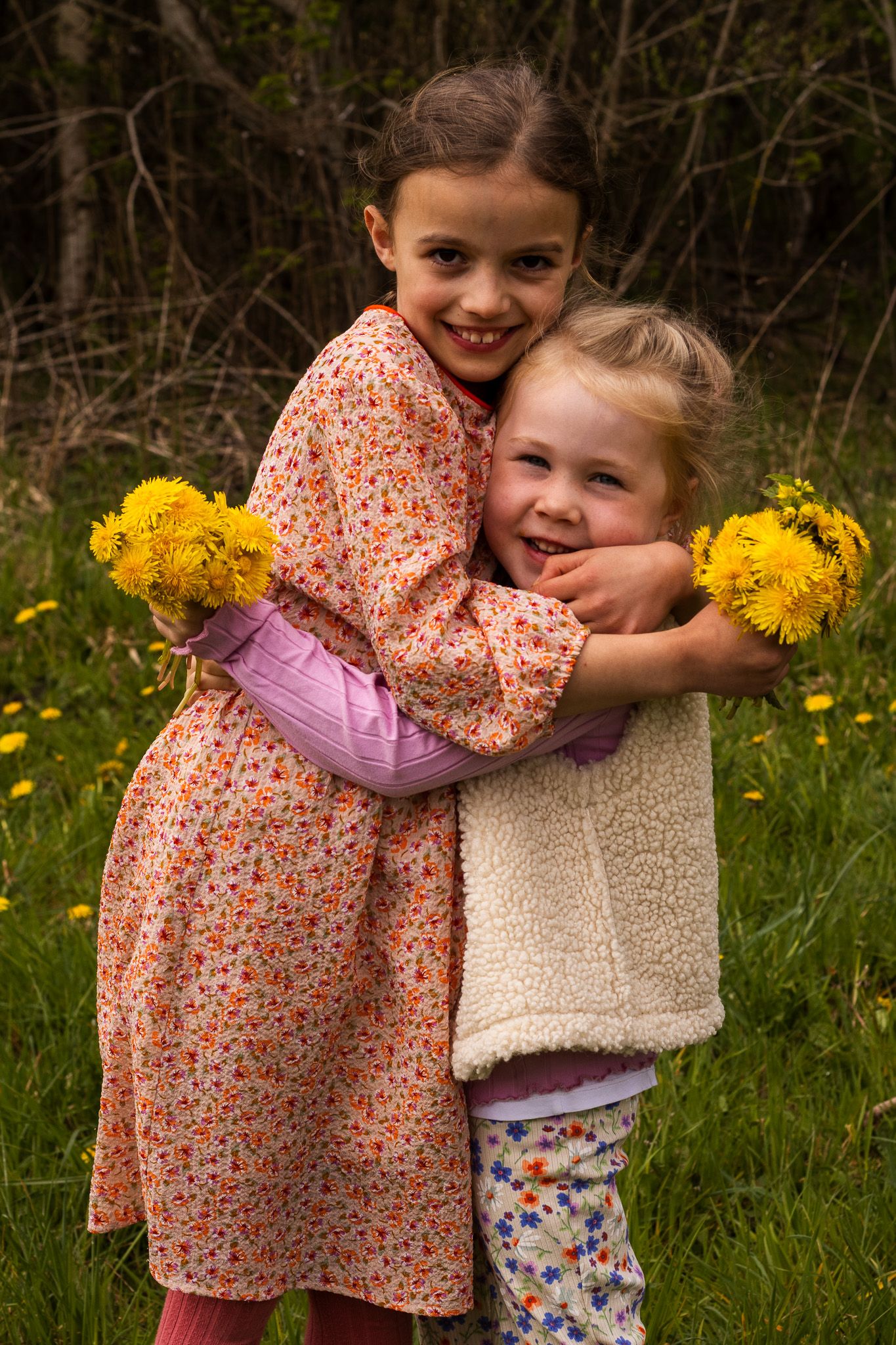 2 nichtjes knuffelen met paardenbloemen