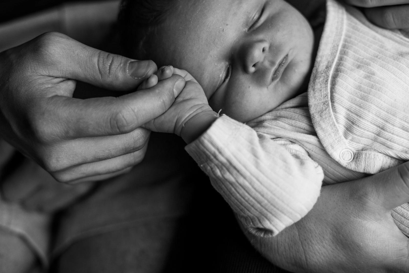 Baby houdt vader vast