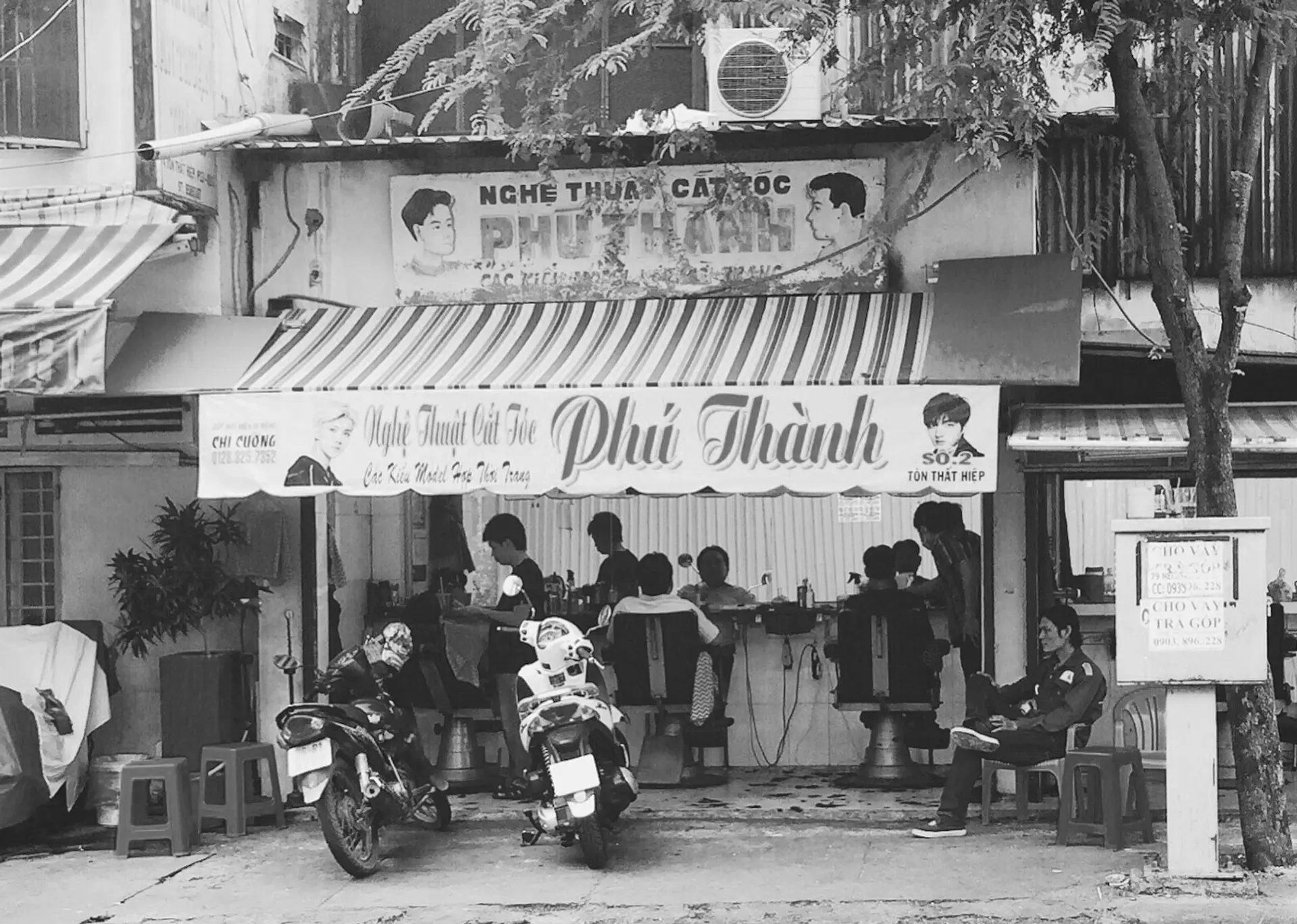 Both hand-painted and printed signs of the barber shop Phú Thành District 11, Saigon (photo by author, 2018)