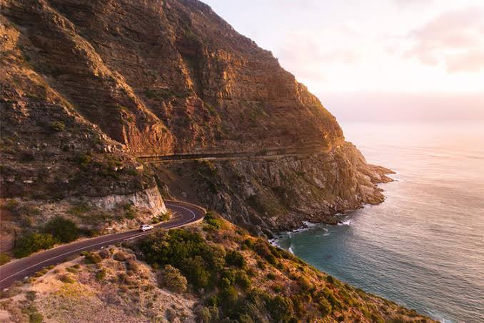 Chapman’s Peak Drive curving along a cliff above the sea at sunset