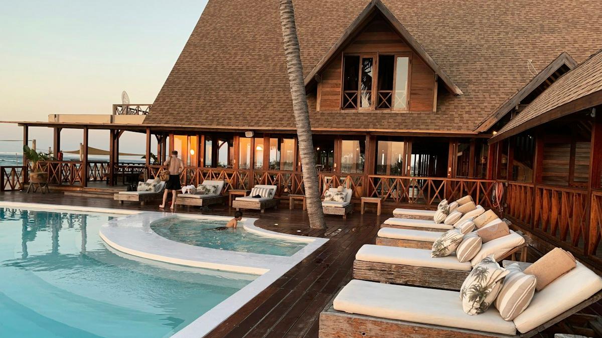 Resort pool deck with sun loungers beside the sea