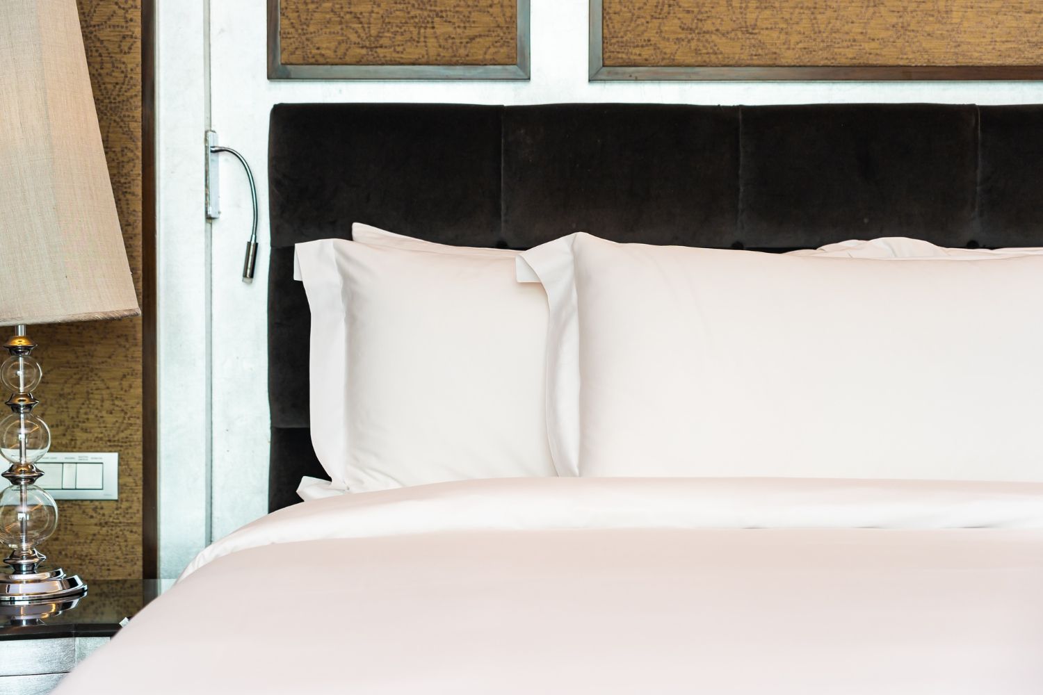 Premium 100% cotton hotel bed linen with crisp white bedsheets and pillowcases in a luxury hotel room