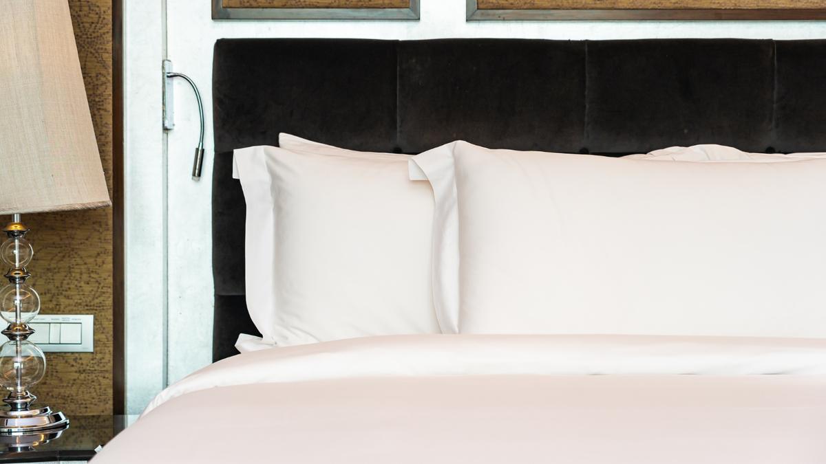 Premium 100% cotton hotel bed linen with crisp white bedsheets and pillowcases in a luxury hotel room