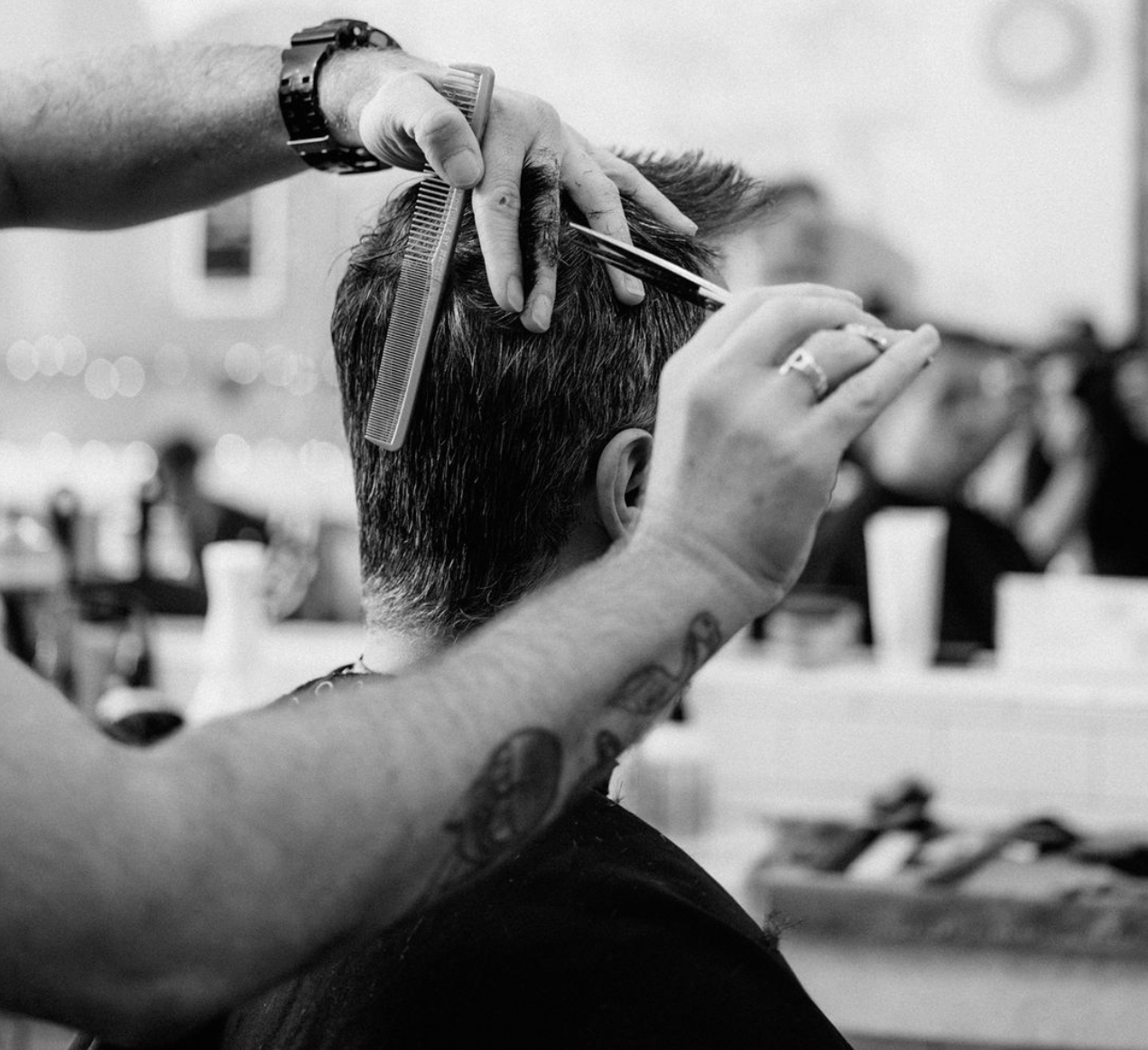 A man getting his haircut at a Rudy's barbershop. 