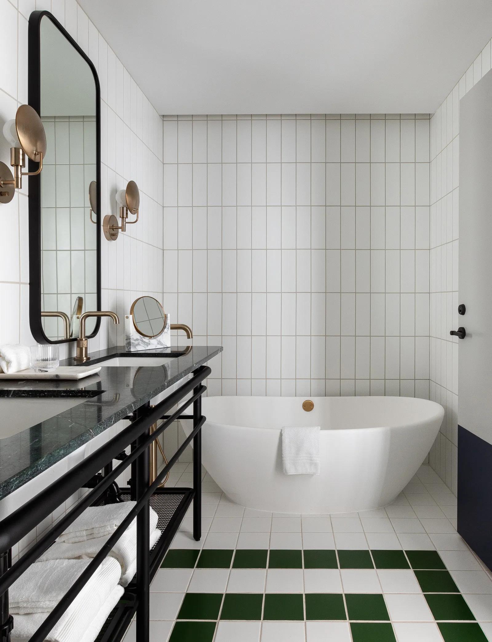 A beautifully green and white tiled bathroom in the Woodlark Hotel