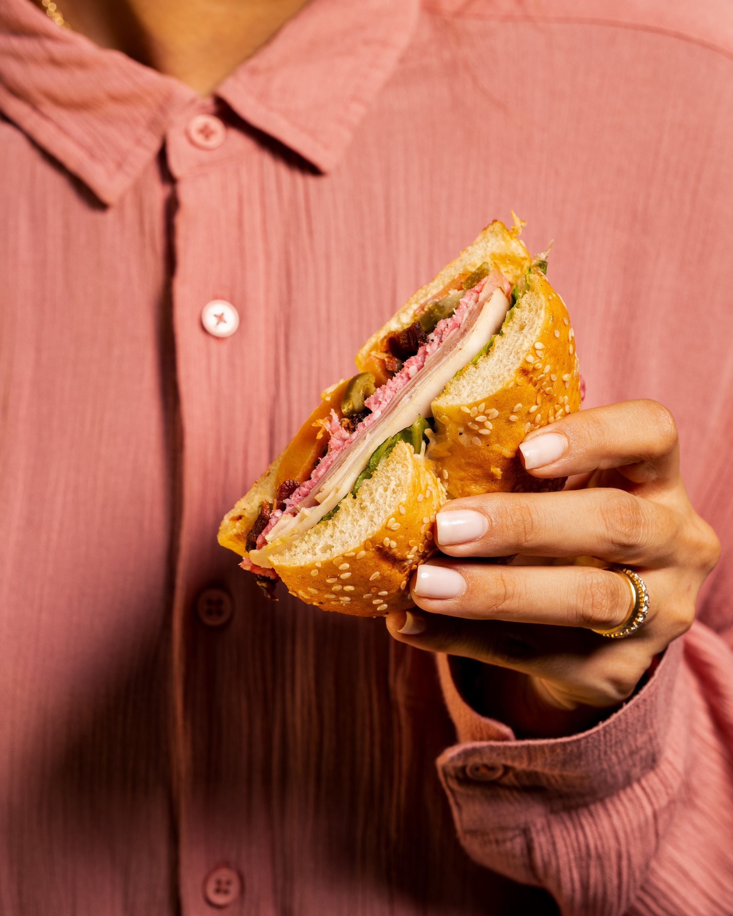 Hand holding sandwich at Ziya restaurant, food photography by Efem Studios