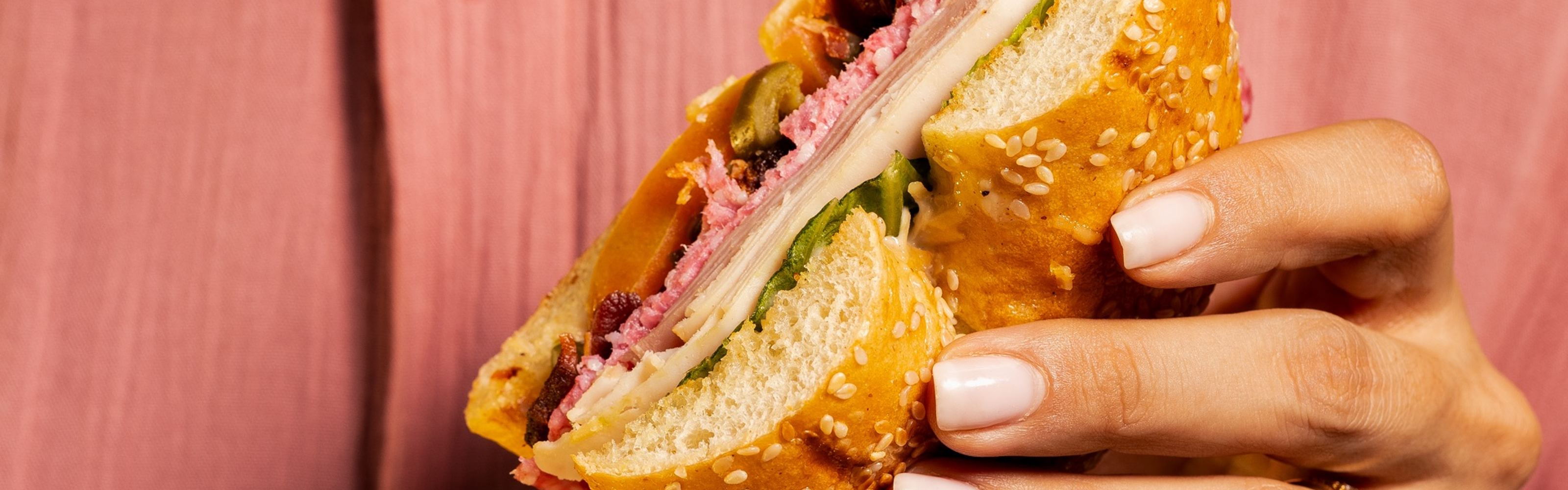Hand holding sandwich at Ziya restaurant, food photography by Efem Studios