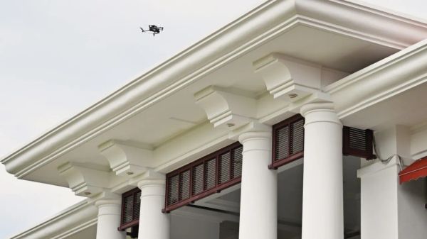 Drone flying near the cornice of a colonnaded building facade