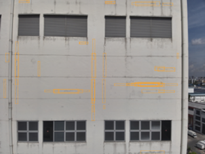 Building facade with orange markings highlighting defect locations