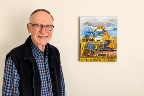 elderly resident stands next to painting of development at Lincoln Plains