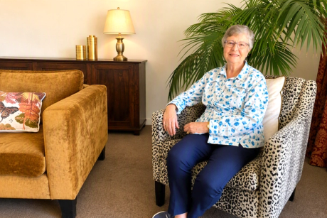 elderly lady sitting in an armchair with cheetah skin pattern material