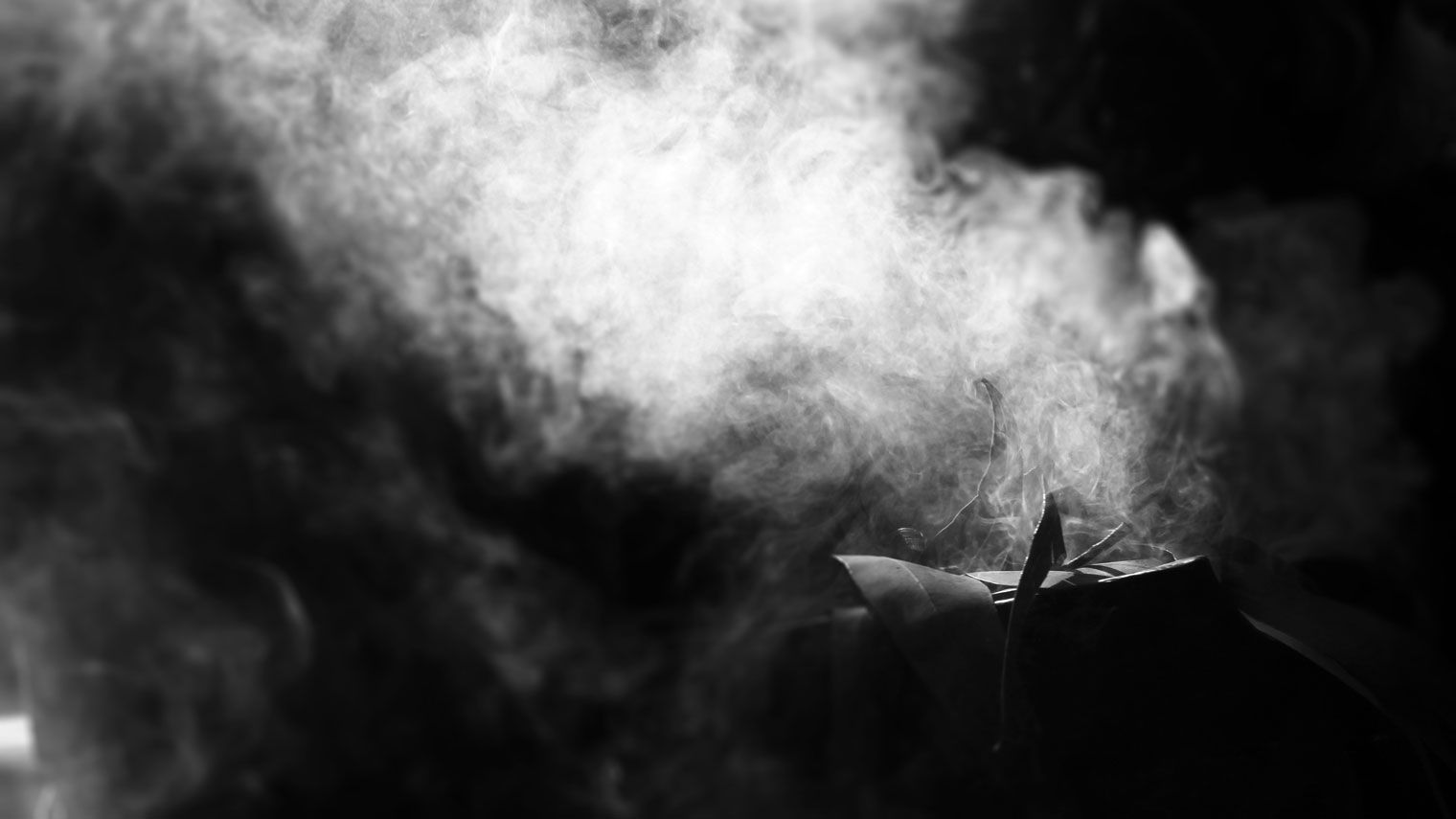 Smoke rises in the darkness.