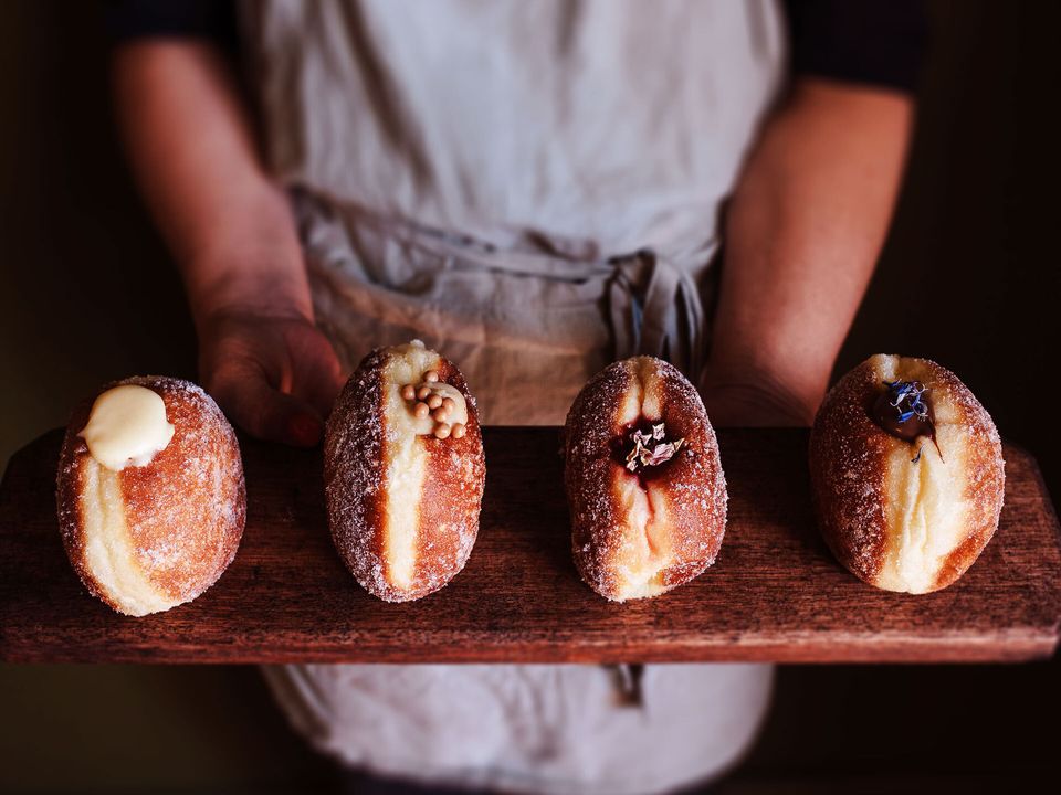 Four doughnuts on a wooden platter.